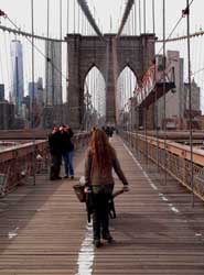 Rhea Marmentini wheel barrowing stones over the Brooklyn Bridge.